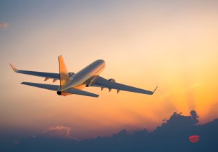 Passenger airplane flying above clouds during sunrise