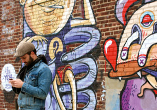 One of Brooklyn's many resident hipsters takes a break alongside some local street art.