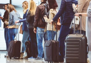 People lining up with carry-on baggage to board a flight