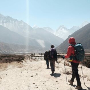 group tour hiking towards himalayan mountain ranges