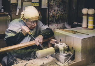 An artisan making a kokeshi doll