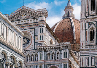 The Duomo peeking through beautiful buildings in Florence.