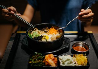 Woman eating bibimbap in Korean restaurant