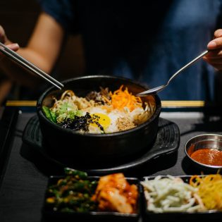 Woman eating bibimbap in Korean restaurant