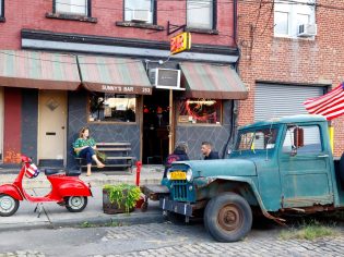 a woman sitting outside Sunny's Bar, Red Hook, NYC