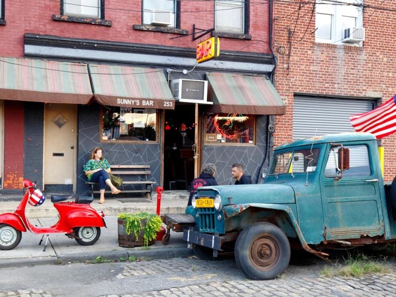a woman sitting outside Sunny's Bar, Red Hook, NYC