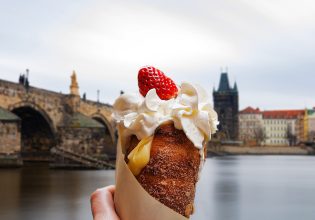 a hand holding Trdelník in Prague