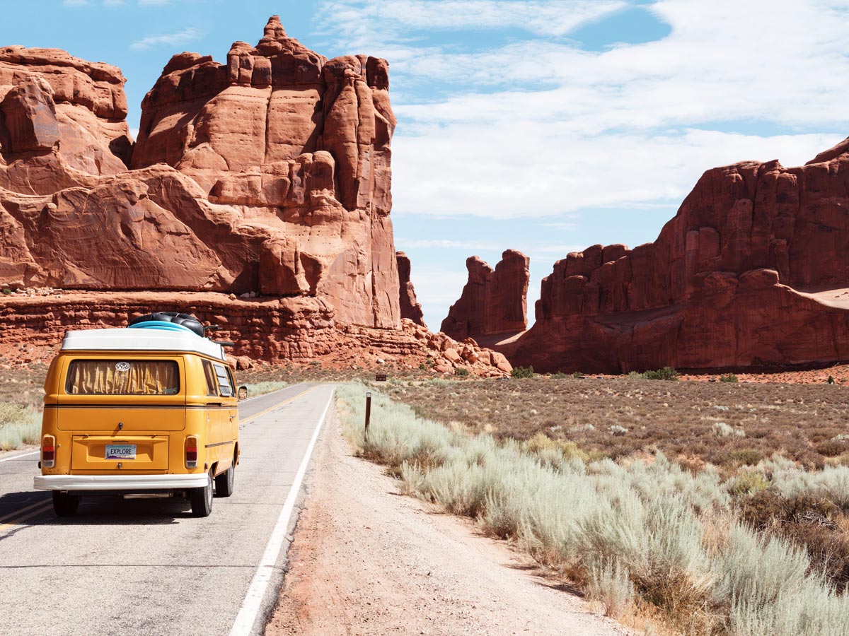 Yellow Volkswagen bus driving through Utah